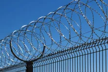 A concertina wire on a fence made of welded grid panels